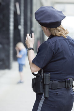 Woman police officer talking on hand mike.
