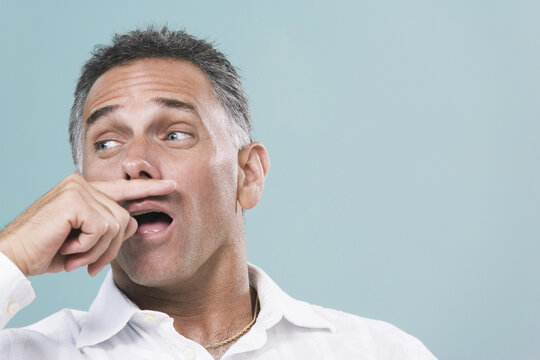 Close-up of a mid adult man sneezing