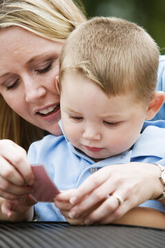 View of a woman showing a playing card to her son in American Sign Language.