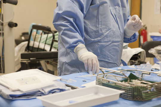 Surgical technologist setting  up back table of instruments prior for cataract surgery