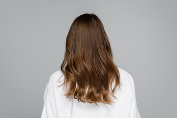 back view of young woman with shiny and healthy hair isolated on grey
