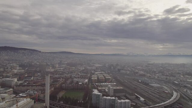 360 degrees round shot of City of Zürich with Swiss Alps, Lake Zürich, local mountain Uetliberg and industrial district on a cloudy winter day. Movie shot December 20th, 2022, Zurich, Switzerland.