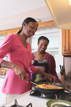 Two sisters cooking in the kitchen, one with learning disability