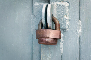 Hanging metal lock on a metal gate close-up.