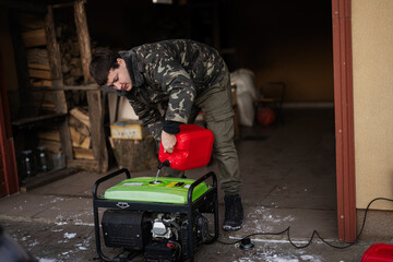 Man wear in military jacket pour gasoline from canister in portable mobile backup standby generator.