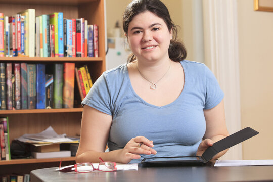 Woman with Asperger syndrome working in her home office with her tablet