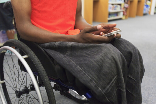 Man who had spinal meningitis in a wheelchair using cell phone