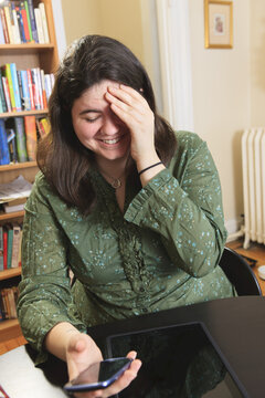 Woman with Asperger syndrome laughing at her text message