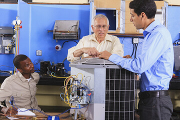Instructor training students about air conditioning units in HVAC classroom
