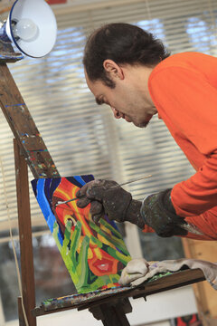 Man with Asperger's painting in his art studio