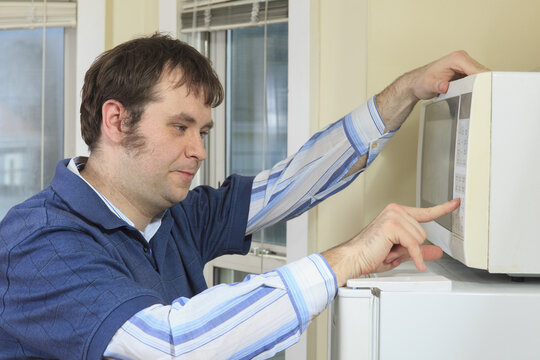 Man with Asperger's living in his home and cooking in microwave