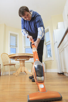 Man with Asperger's living in his home and vacuuming