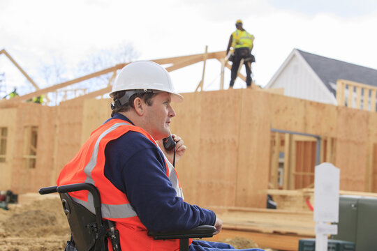Construction engineer with spinal cord injury talking on radio at home construction site
