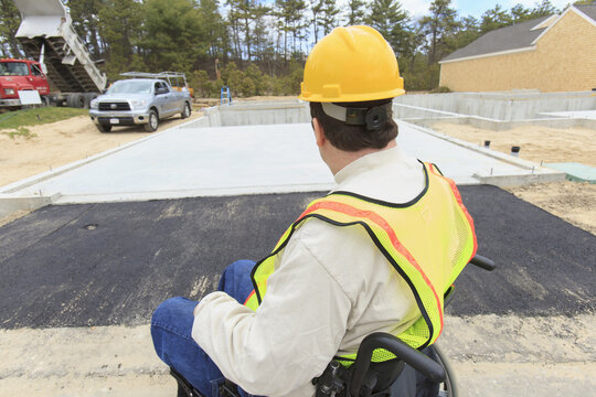 Construction supervisor with Spinal Cord Injury inspecting house foundation work