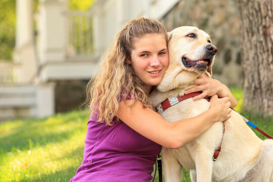Woman with visual impairment hugging  her service dog