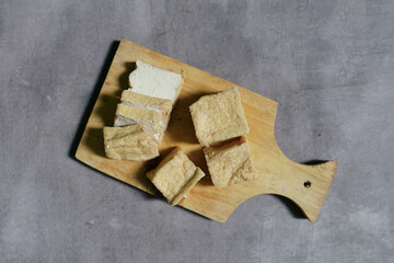 Raw organic vegetarian tofu slices with on wooden background