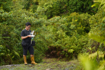 Young male drone pilot looking at monitor to control drone. Male drone pilot