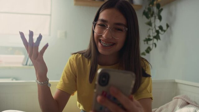 Caucasian teenage girl having video call while spending time on the bedroom. Shot with RED helium camera in 8K.  