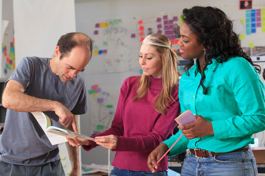 Engineering instructor with Aspergers reviewing technical material with students in ideation lab