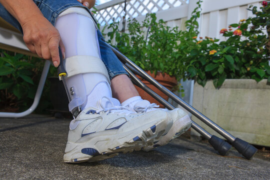 Woman with Spina Bifida adjusting leg brace so she can walk