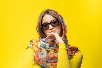 Portrait of a smiling young woman on a yellow background.