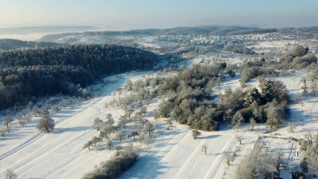 Aerial footage of flight over snowy winter landscape in Southern Germany