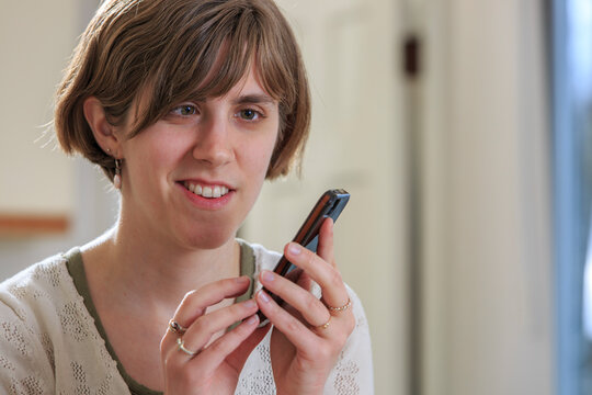 Blind woman using assistive technology to listen to texts on her cell phone