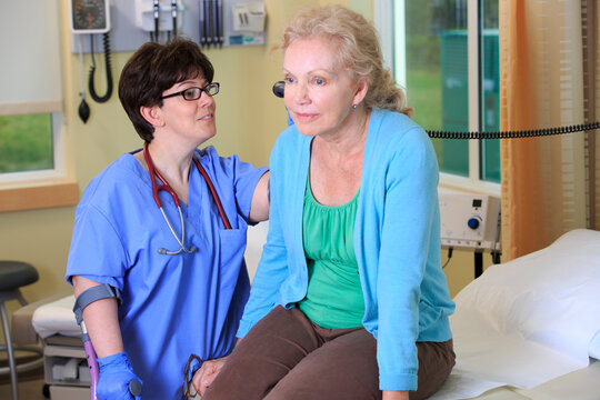 Nurse with Cerebral Palsy on canes checking a patient's ears in a health clinic