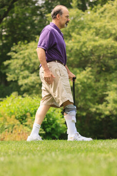 Man with ankle sprain walking with cane