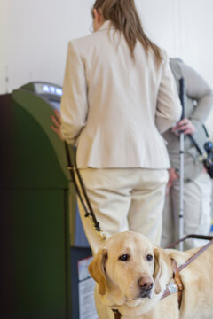 Two young blind women using a bank ATM