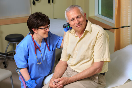 Nurse with Cerebral Palsy checking the ears of a patient in a clinic