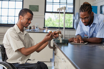 Students who had Spinal Meningitis setting up conservation of energy experiment in laboratory