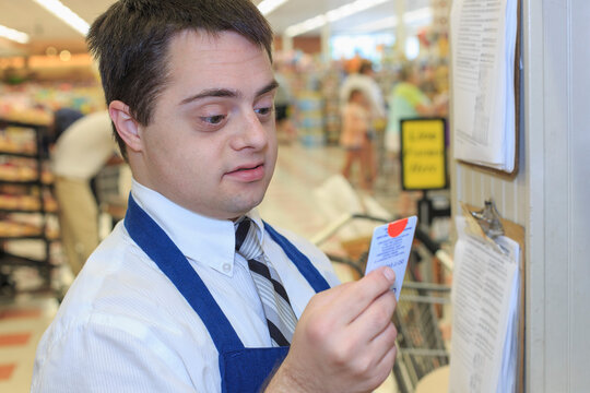 Man with Down Syndrome checking his schedule for work at a grocery store