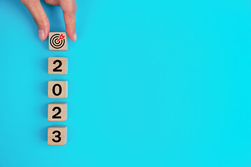 2023 New Year Goal Target, Action, Plan, Idea, Inspiration Concept. 2023 wooden cube with target icon on light blue background. 2023 Concept.