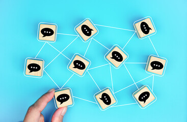 Concept of online communication or social network, wooden cubes with speech bubbles linked to each...