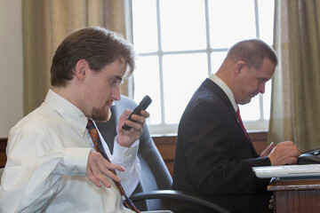 Man with Down Syndrome working with a collaborator using a phone in the State Capitol office
