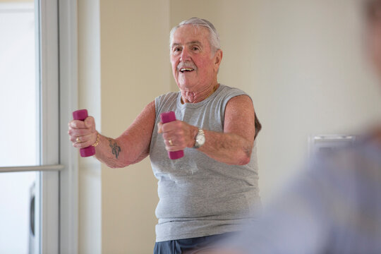 Happy senior man exercising in gym