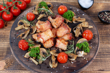 Grilled bacon-wrapped chicken tenders with rosemary and grilled vegetables 