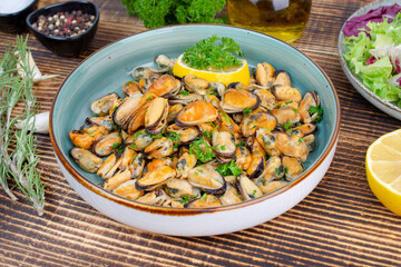 Mussels in wine with parsley and lemon. Seafood. Delicious snack for gourmands. Close up