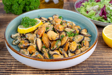 Mussels in wine with parsley and lemon. Seafood. Delicious snack for gourmands. Close up