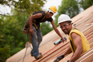 Carpenters working on the roof of a house under construction