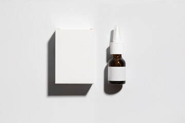Mockup of a box and an amber colored glass bottle, parapharmacy products, lying down, includes tracing