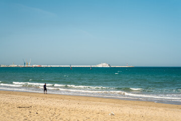 People walking on a Mediterranean beach in Tanger, Morocco