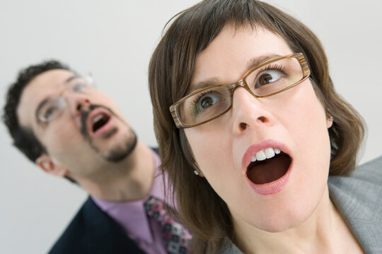 Close-up of a businesswoman looking surprised with her colleague behind her