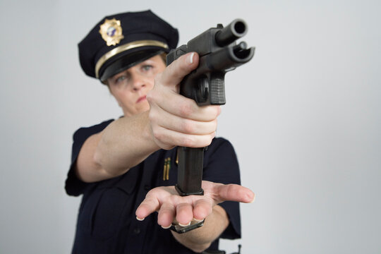 Police woman loading a pistol.