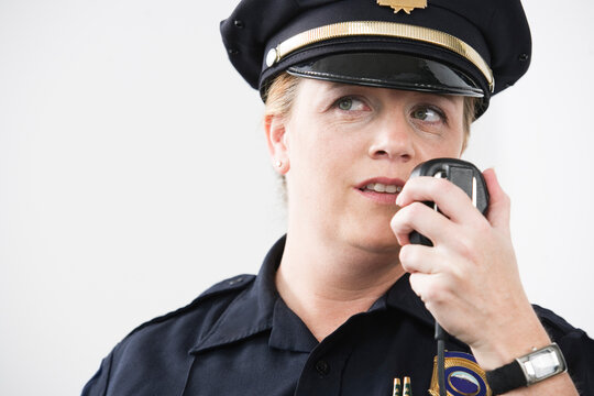 Woman police officer talking on hand mike.
