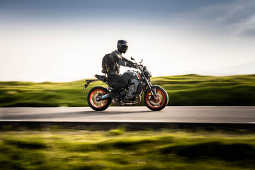 Young guy driving his motorcycle on a mountain road