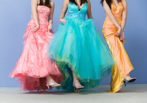 View of friends dancing wearing prom dresses.