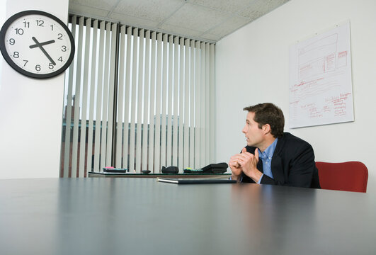 Businessman looking at a clock in an office