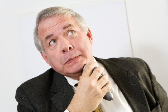 View Of A Mature Man Using An Electronic Shaver.